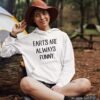 Woman in a camping setting wearing a white hoodie sweatshirt with the text 'Farts are always funny' printed on the front.