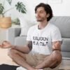 Man meditating while wearing a white t-shirt with the text 'Religion is a cult' printed on the front.