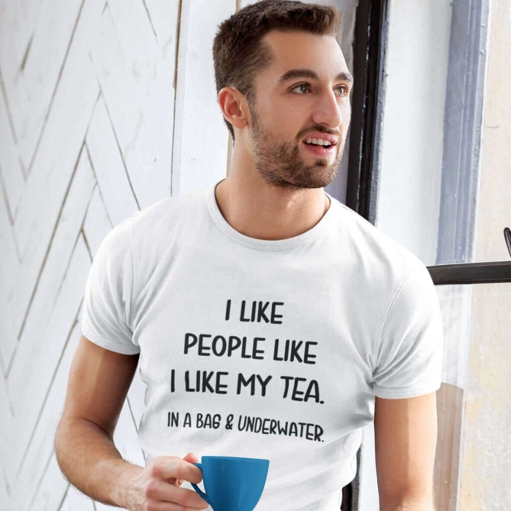 Man holding cup of tea wearing a white t-shirt with the text 'I like people like I like my tea, In a bag & underwater.' printed on the front.