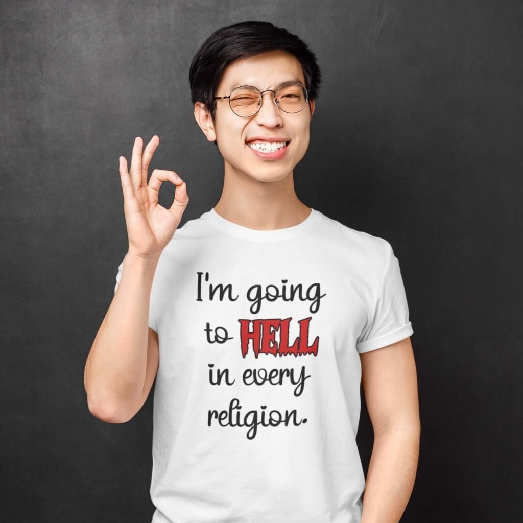 Smiling man wearing a white t-shirt with the text 'I'm going to hell in every religion' printed on the front.