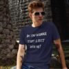 Man wearing sunglass wearing a navy blue t-shirt with the text 'Do you wanna start a cult with me' printed on the front.