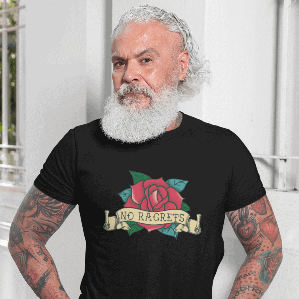 Tattooed bearded man wearing a black t-shirt with a funny image of an old school rose flash tattoo & the words 'No ragrets'. The word regrets is intentionally misspelled.