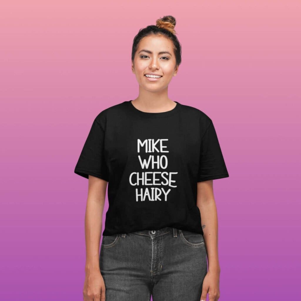 Smiling woman wearing black pun t-shirt with the text 'Mike who cheese hairy' printed on the front.