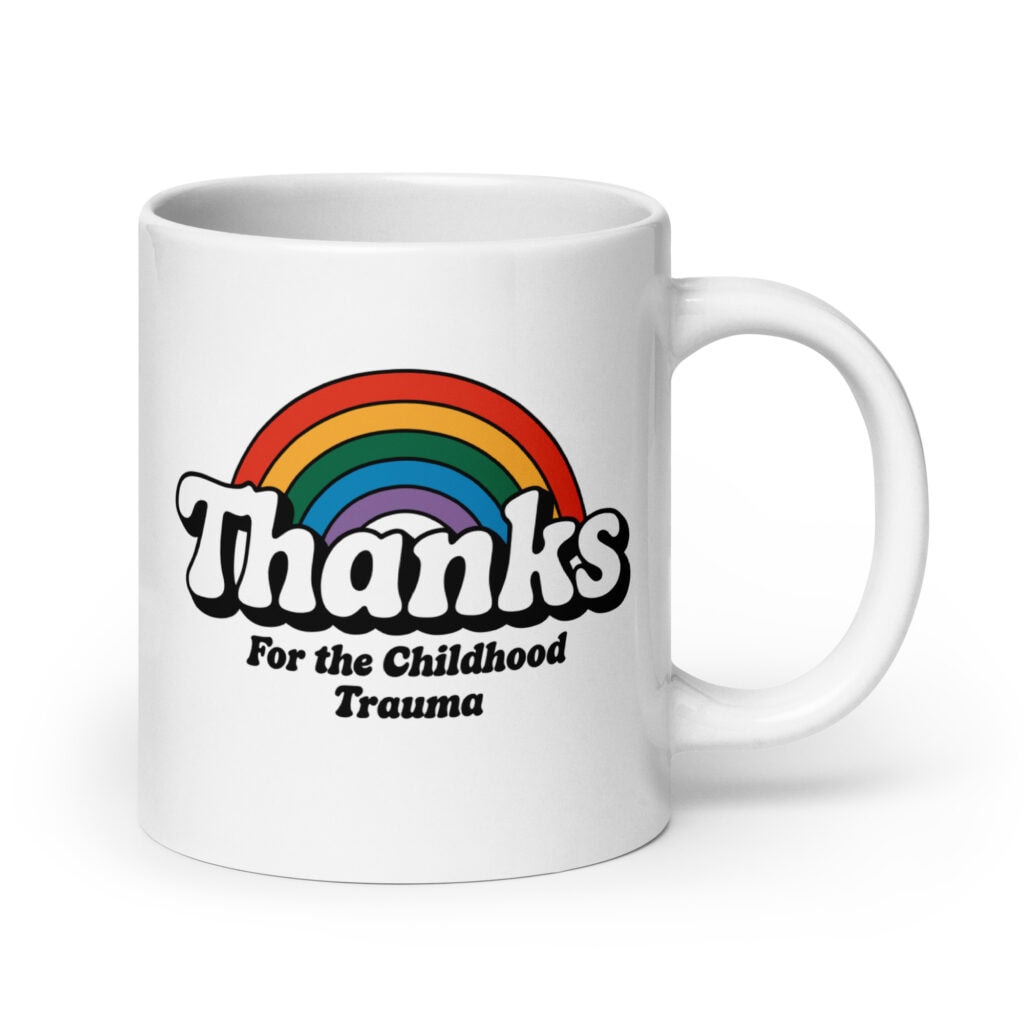 White ceramic mug with a rainbow and the text "Thanks for the childhood trauma' printed on both sides.