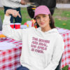 Woman wearing a white hoodie sweatshirt with the text 'The boobs are real, the smile is fake.' printed in pink on the front.