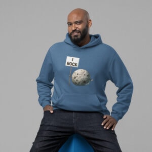 Man sitting on a stool wearing an indigo blue hoodie sweatshirt. The hoodie has an image of a grey rock that is holding a sign. The sign says 'I Rock.' The image is printed on the front of the hoodie.