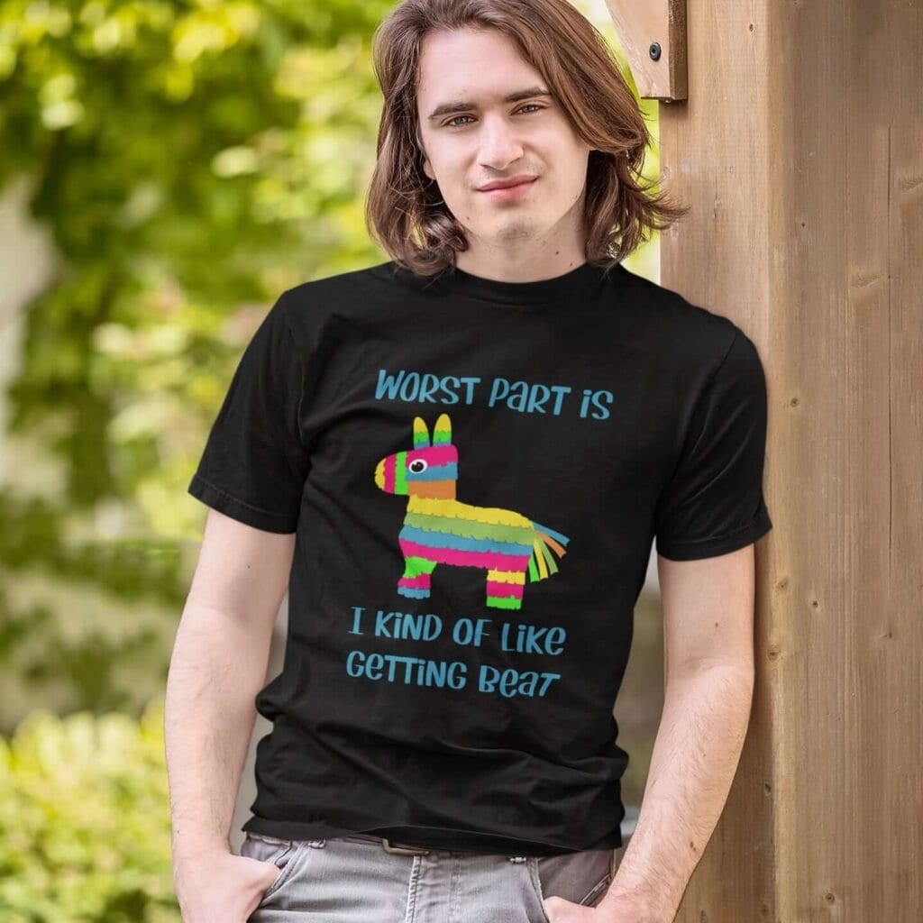 Man wearing a black t-shirt with an image of a colorful donkey pinata with the words 'Worst part is I kind of like getting beat' printed on the front.