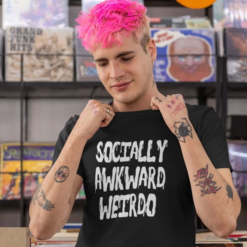 Man with bright pink hair wearing black t-shirt with the text 'Socially awkward weirdo' printed on the front.