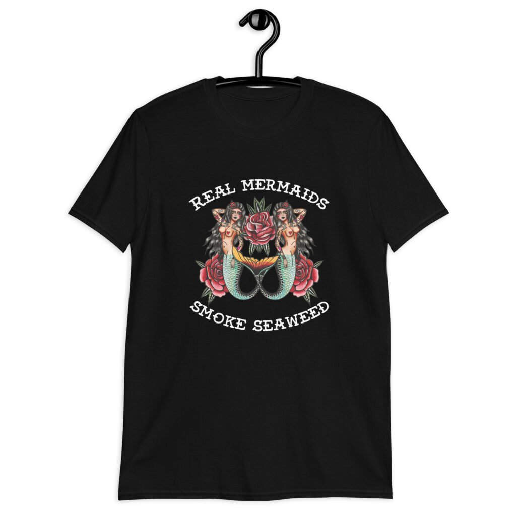 Black t-shirt with image of 2 mermaids and the text 'Real mermaids smoke seaweed' printed on the front.