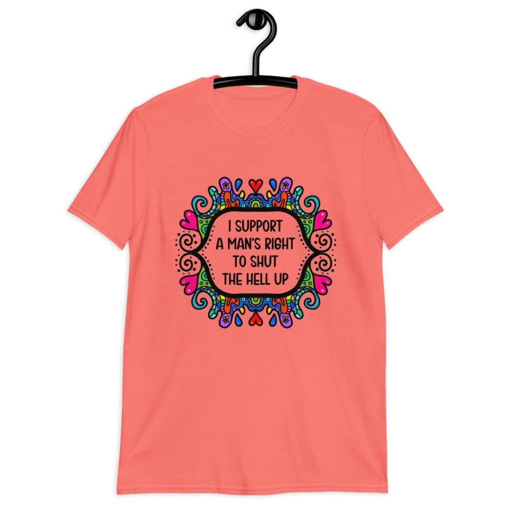 Coral color t-shirt with a colorful doodle graphic and the words 'I support a man's right to shut the hell up.' The design is printed on the front.