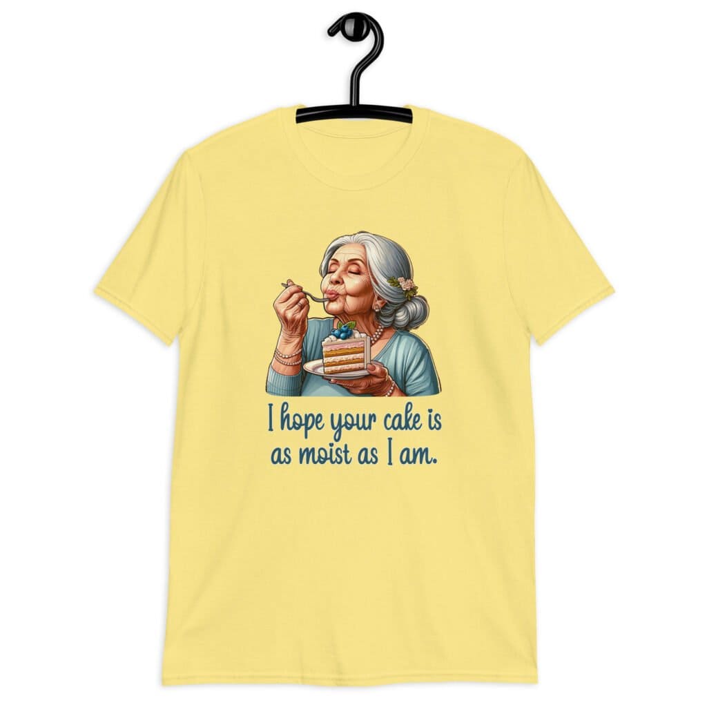 Cornsilk yellow t-shirt with an image of grey haired older woman enjoying a bite of a piece of cake with the words 'I hope your cake is as moist as I am' printed on the front.