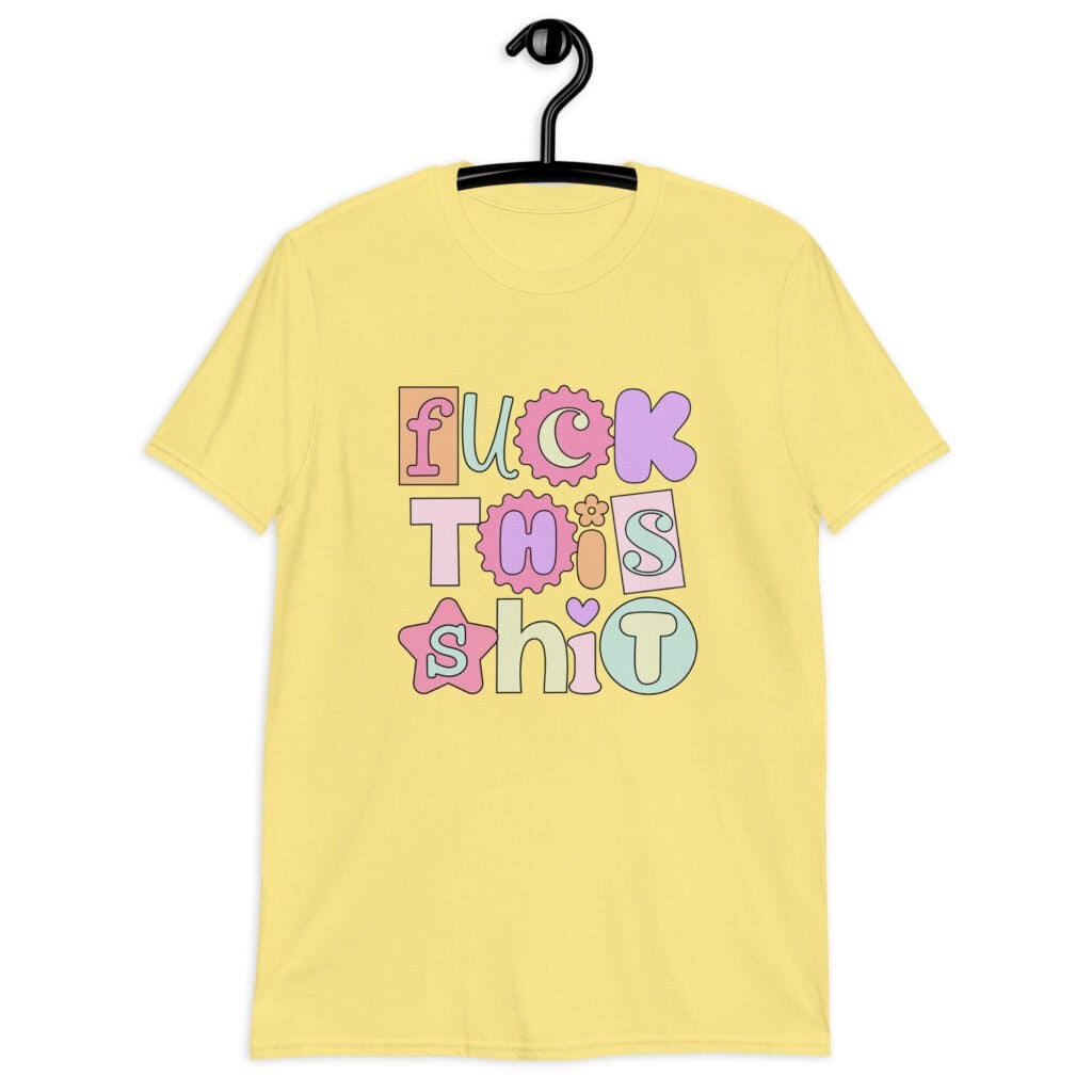 Cornsilk yellow t-shirt with colorful pastel font 'Fuck this shit' graphics printed on the front.