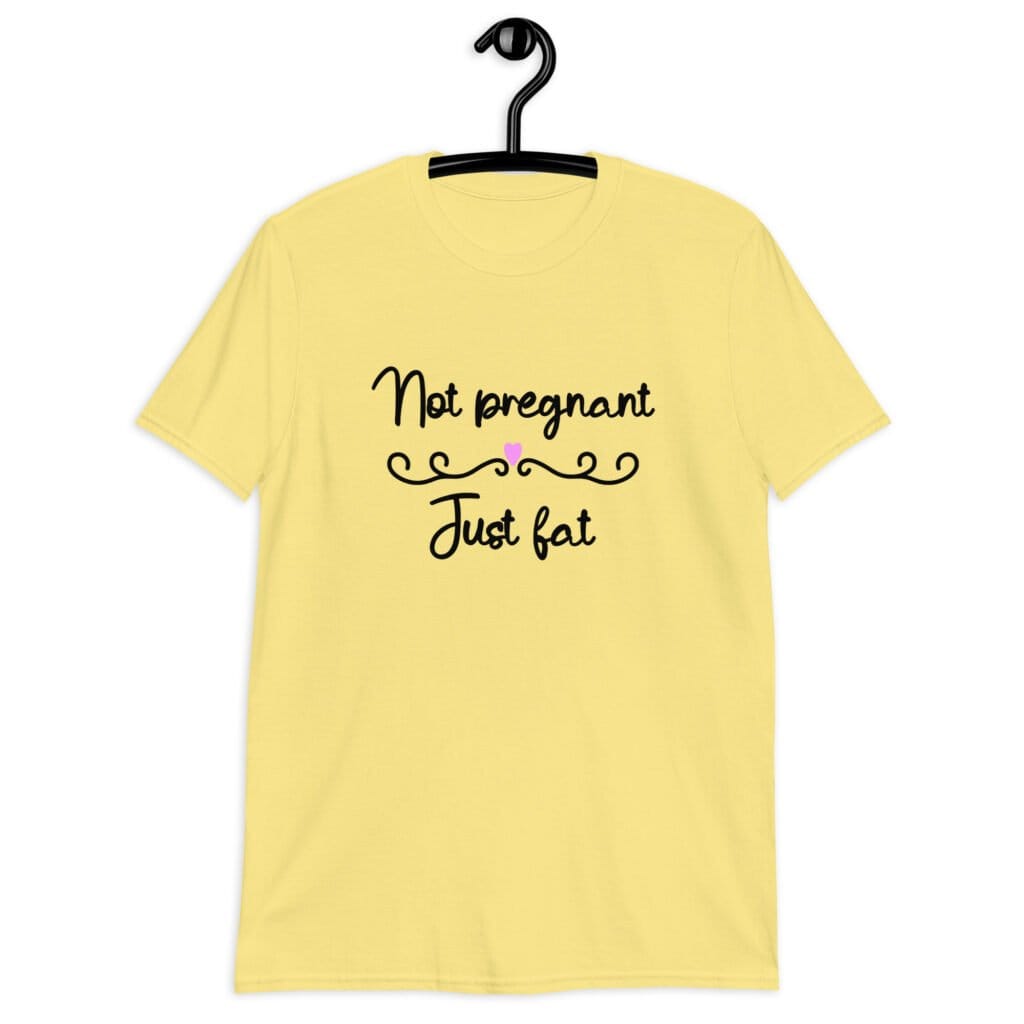 Cornsilk yellow t-shirt with the words 'Not pregnant just fat' printed on the front with a heart.