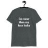 Dark heather grey t-shirt with the text 'I'm nicer than my face looks' printed on the front.