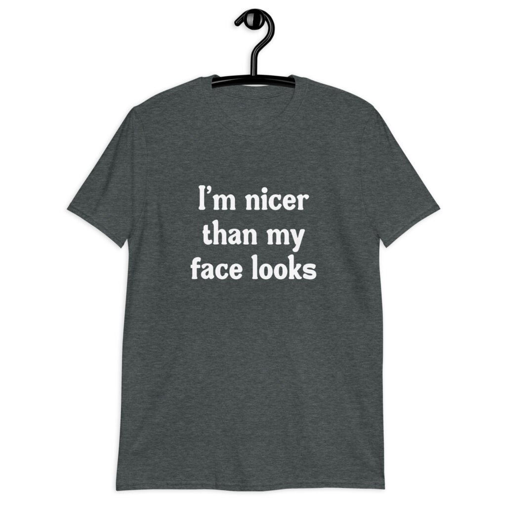Dark heather grey t-shirt with the text 'I'm nicer than my face looks' printed on the front.