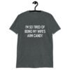 Dark heather grey t-shirt with the funny phrase 'I'm so tired of being my wife's arm candy' printed on the front.