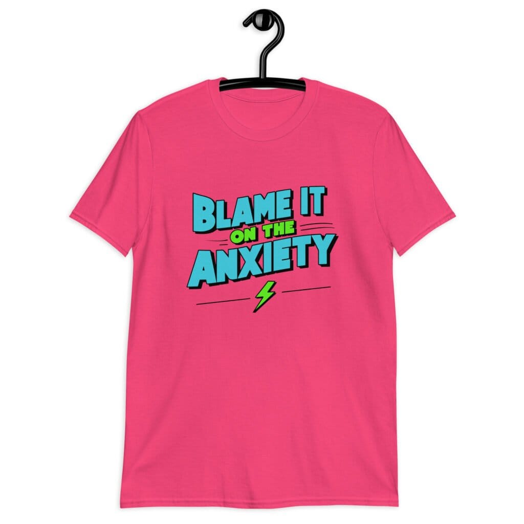 Heliconia pink t-shirt with the phrase 'Blame is on the anxiety' printed on the front. The graphics are bold and in aqua and lime green.