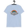 Light blue t-shirt with an image of a rainbow and the words 'Thanks for the childhood trauma' printed on the front. The word Thanks is large and the rest of the words are smaller under.