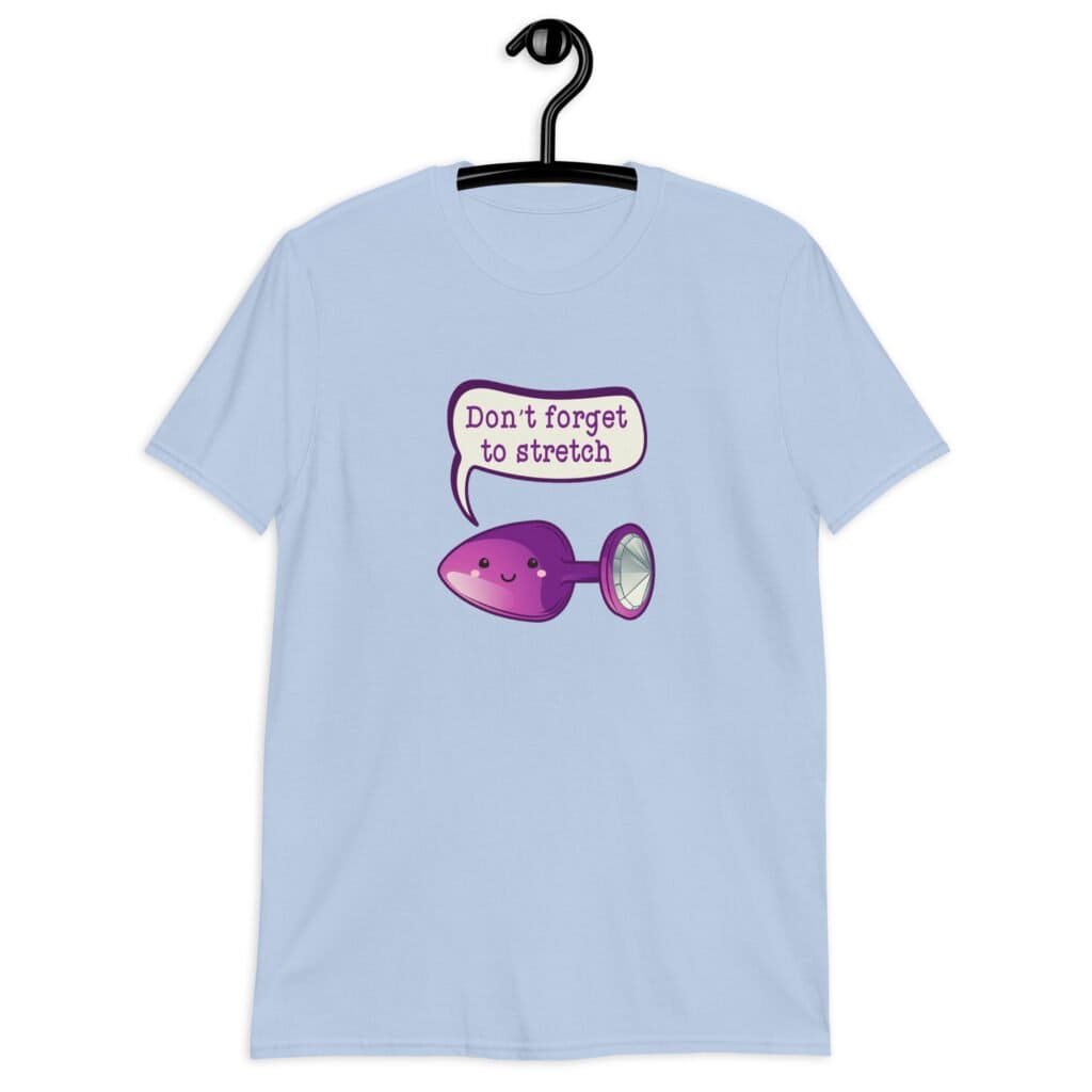 Light blue t-shirt that has image of a purple anal plug with a smile face. There is a speech bubble above with the words 'Don't forget to stretch'. The graphics are printed on the front of the shirt.
