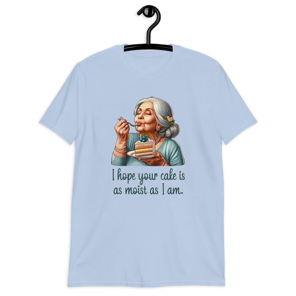 Light blue t-shirt with an image of grey haired older woman enjoying a bite of a piece of cake with the words 'I hope your cake is as moist as I am' printed on the front.