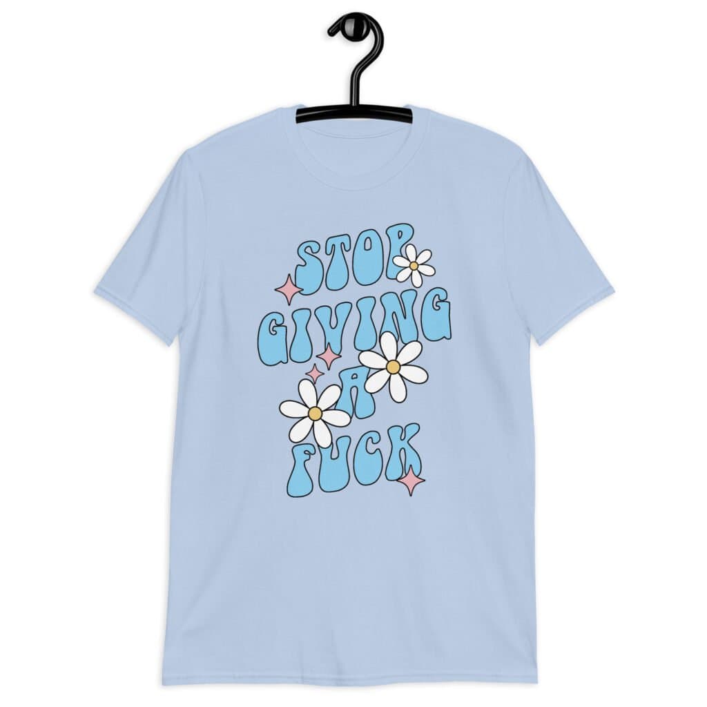 Light blue t-shirt with a retro daisy and star design and the text 'Stop giving a fuck' printed on the front.