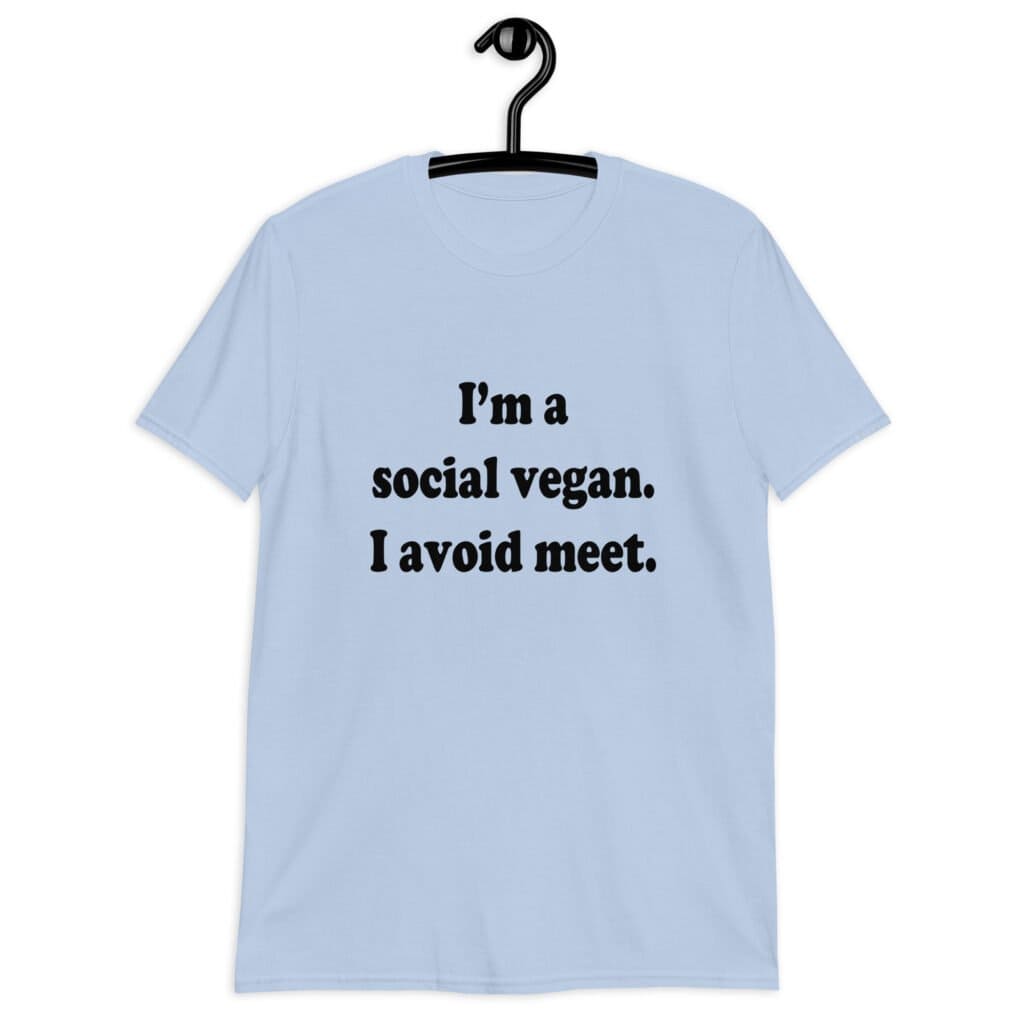 Light blue t-shirt with the pun phrase 'I'm a social vegan. I avoid meet.' printed on the front.
