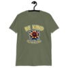 Military green t-shirt with an image of a flower and the words Be kind above the flower in yellow bold block font. The words Of a bitch are smaller in script font under the flower. The design is printed on the front of the shirt.