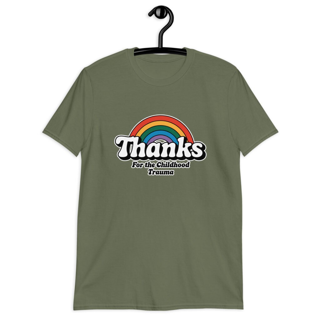 Military green t-shirt with an image of a rainbow and the words 'Thanks for the childhood trauma' printed on the front. The word Thanks is large and the rest of the words are smaller under.