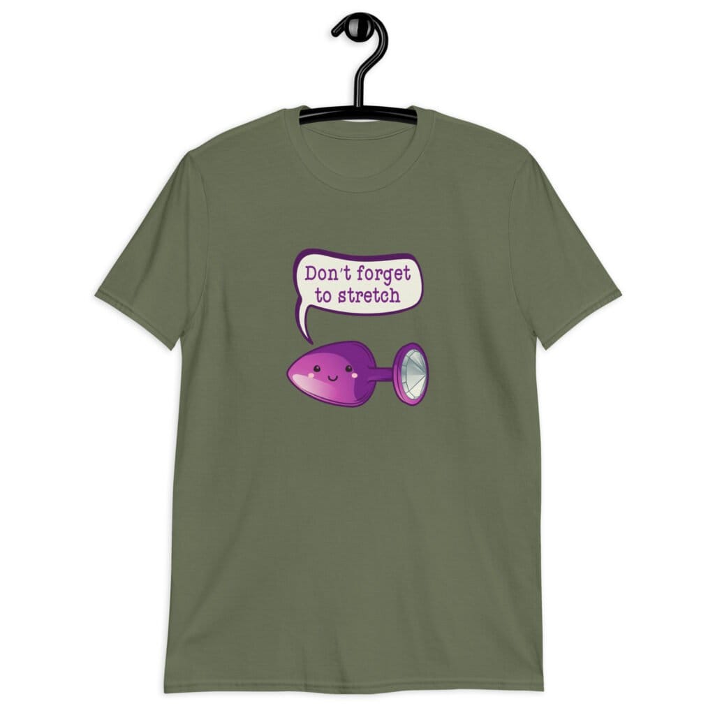 Military green t-shirt that has image of a purple anal plug with a smile face. There is a speech bubble above with the words 'Don't forget to stretch'. The graphics are printed on the front of the shirt.