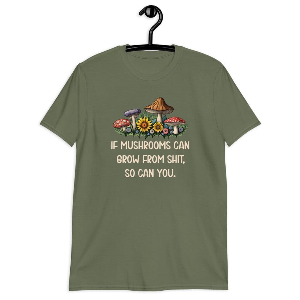 Military green t-shirt with images of mushrooms and the text 'If mushrooms can grow from shit, so can you.' printed on the front.
