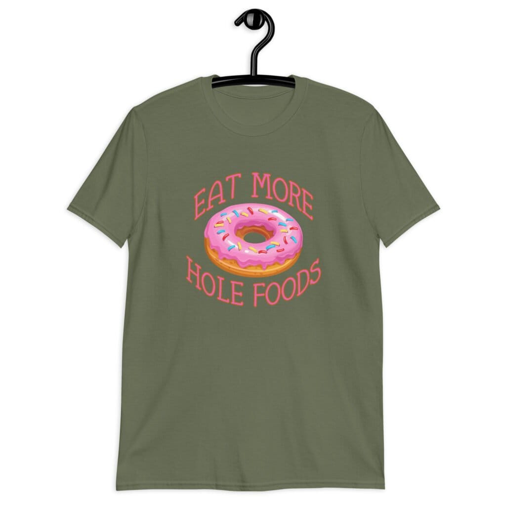 Military green t-shirt that has an image of a donut with pink icing and sprinkles and the text 'Eat more hole foods' printed on the front.