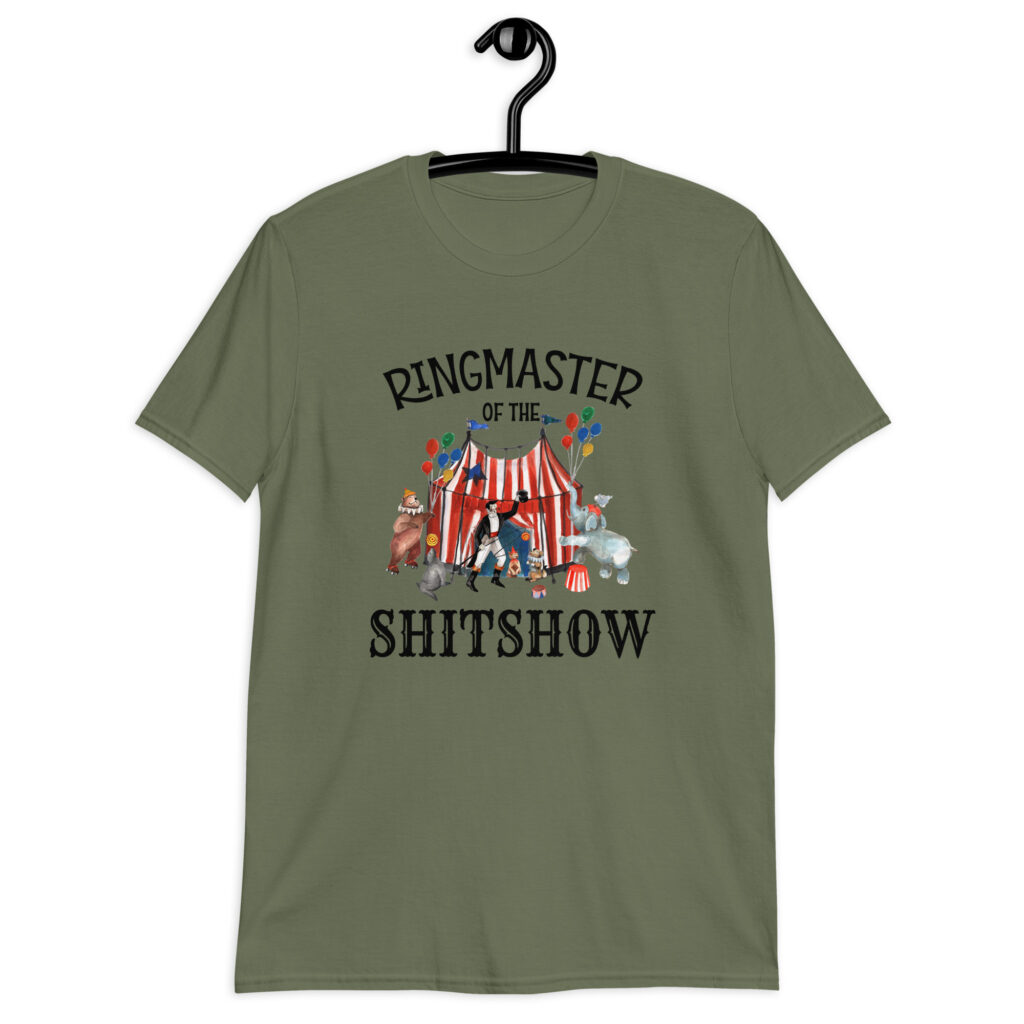 Military green t-shirt with a circus theme graphic and the text 'Ringmaster of the Shitshow' printed on the front.