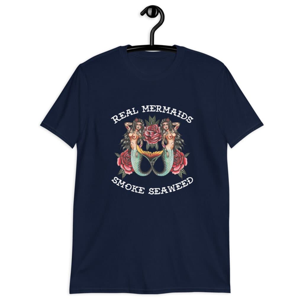 Navy blue t-shirt with image of 2 mermaids and the text 'Real mermaids smoke seaweed' printed on the front.