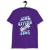 Purple t-shirt with a retro daisy and star design and the text 'Stop giving a fuck' printed on the front.