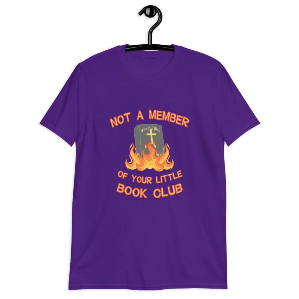 Purple t-shirt with image of a burning bible and the text 'Not a member of your little book club' printed on the front.