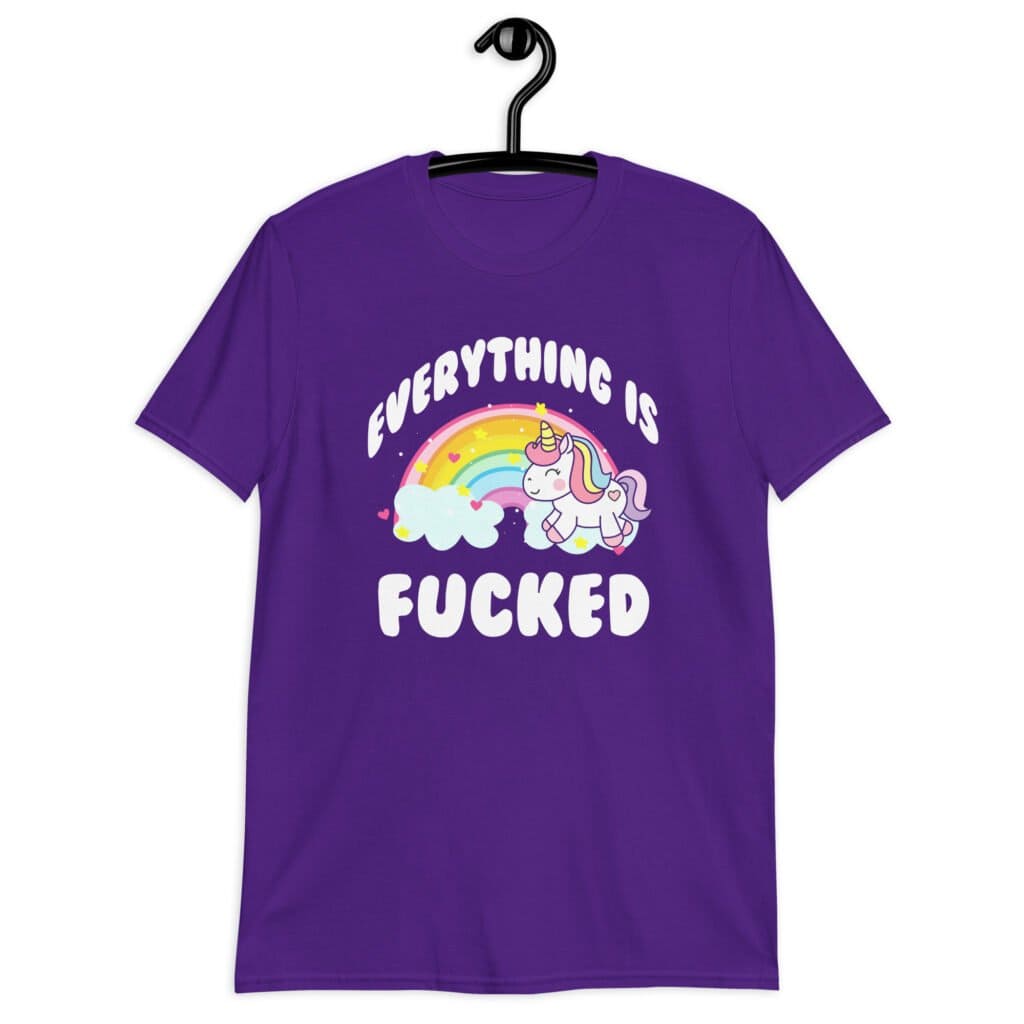Purple t-shirt with a graphic of a kawaii style unicorn and a pastel rainbow with the text 'Everything is fucked' printed on the front.