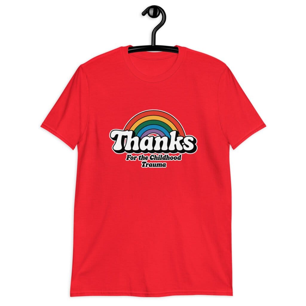 Red t-shirt with an image of a rainbow and the words 'Thanks for the childhood trauma' printed on the front. The word Thanks is large and the rest of the words are smaller under.