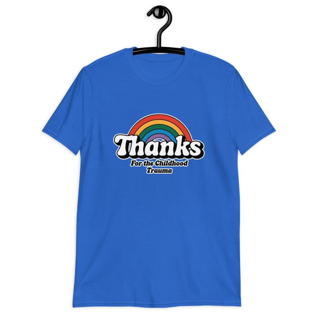 Royal blue t-shirt with an image of a rainbow and the words 'Thanks for the childhood trauma' printed on the front. The word Thanks is large and the rest of the words are smaller under.