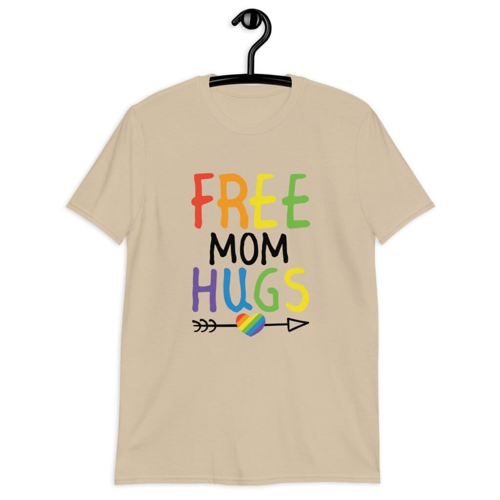 Sand color t-shirt with the text 'Free Mom hugs' in rainbow lettering printed on the front.