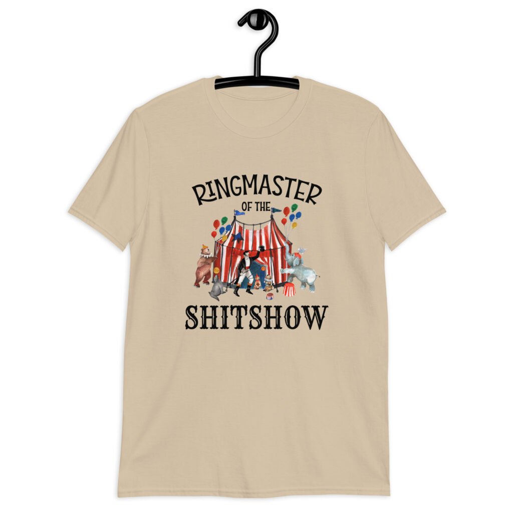 Sand color t-shirt with a circus theme graphic and the text 'Ringmaster of the Shitshow' printed on the front.