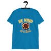 Sapphire bllue t-shirt with an image of a flower and the words Be kind above the flower in yellow bold block font. The words Of a bitch are smaller in script font under the flower. The design is printed on the front of the shirt.
