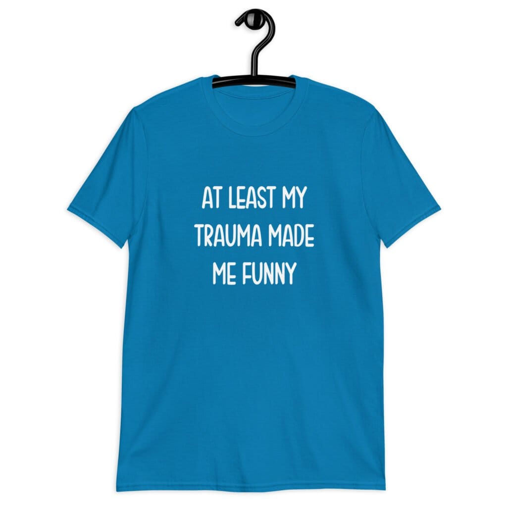 Sapphire blue t-shirt with the text 'At least my trauma made me funny' printed on the front.