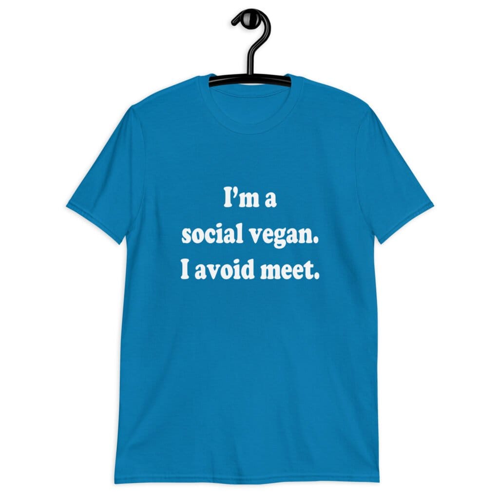 Sapphire blue t-shirt with the pun phrase 'I'm a social vegan. I avoid meet.' printed on the front.