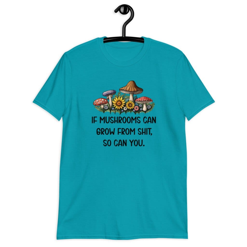 Tropical blue t-shirt with images of mushrooms and the text 'If mushrooms can grow from shit, so can you.' printed on the front.