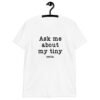 White t-shirt with the text 'Ask me about my tiny penis' printed on the front. The word tiny is much smaller than the rest of the text.