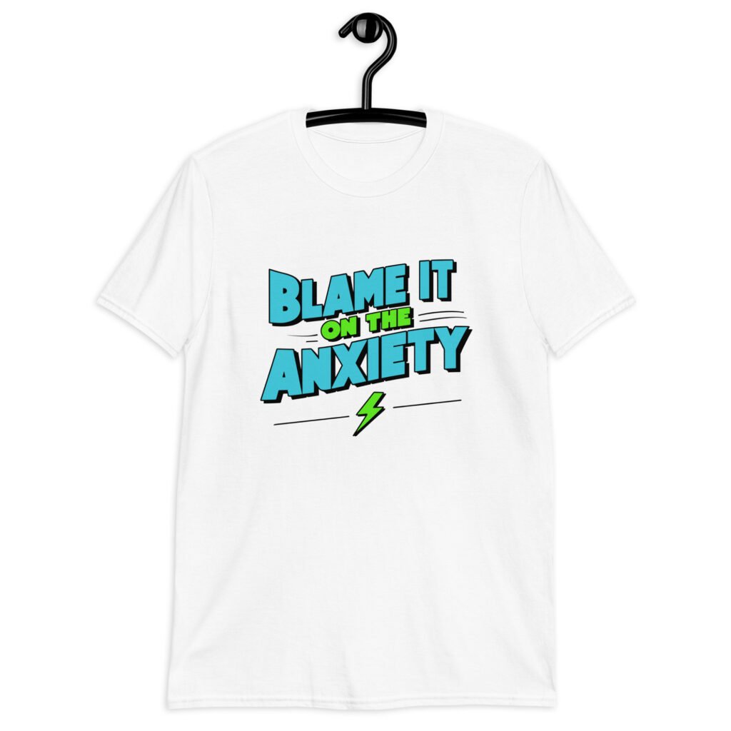 White t-shirt with the phrase 'Blame is on the anxiety' printed on the front. The graphics are bold and in aqua and lime green.
