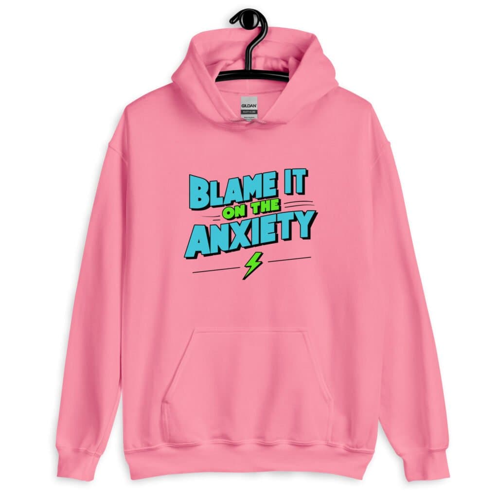 Azalea pink hoodie sweatshirt with the phrase 'Blame is on the anxiety' printed on the front. The graphics are bold and in aqua and lime green.