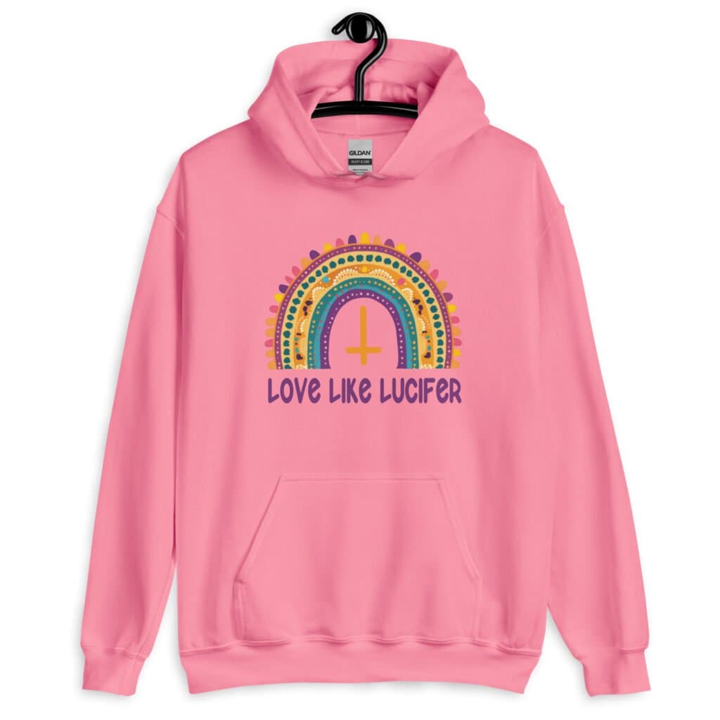 Azalea pink hoodie sweatshirt with an image of a boho style rainbow. There is an upside down cross in the center arch of the rainbow and the text 'Love like Lucifer' printed under. The graphics are printed on the front.