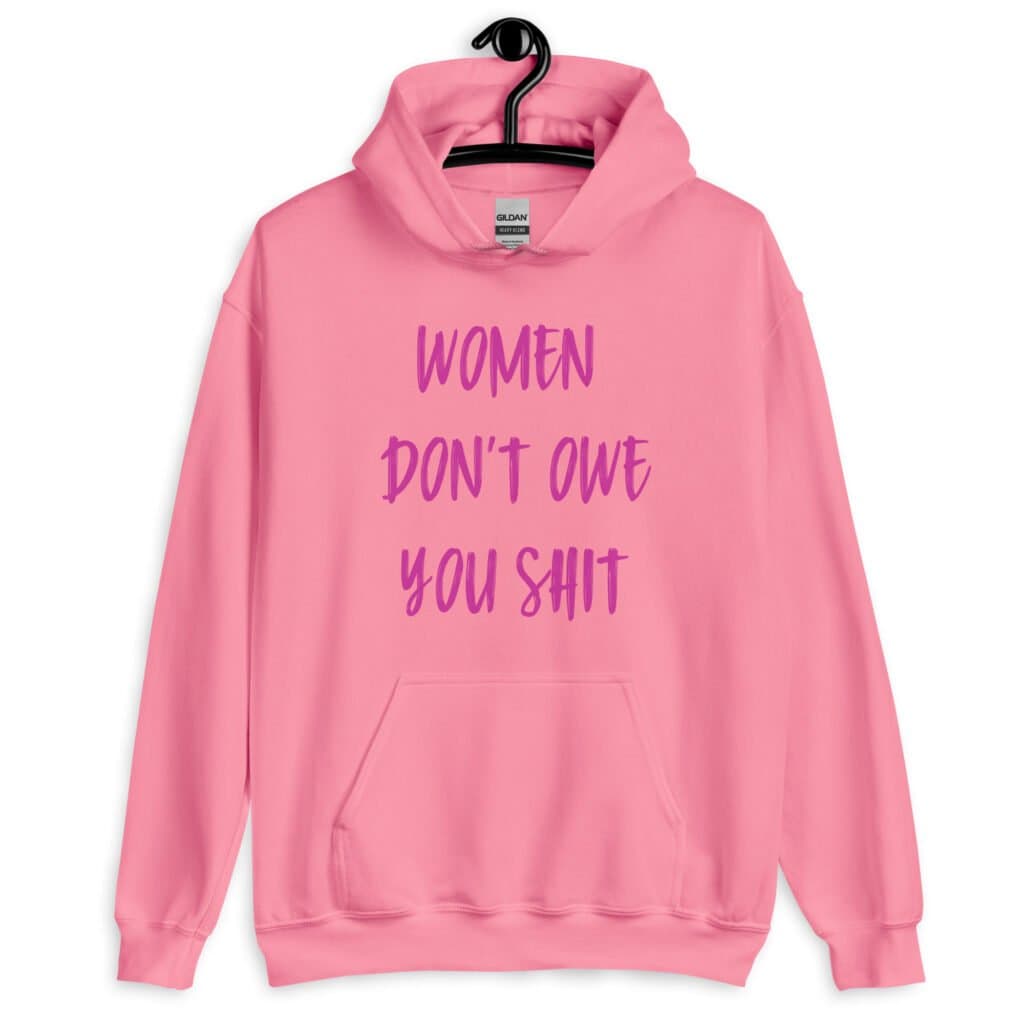 Azalea pink hoodie sweatshirt with the words 'Women don't owe you shit' printed on the front in pink.