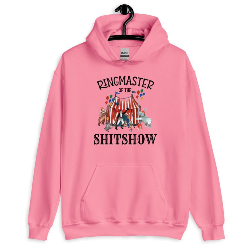 Azalea pink hoodie sweatshirt with a circus theme graphic and the text 'Ringmaster of the Shitshow' printed on the front.